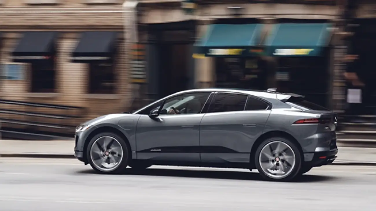 Jaguar I-Pace driving on a road, side profile view