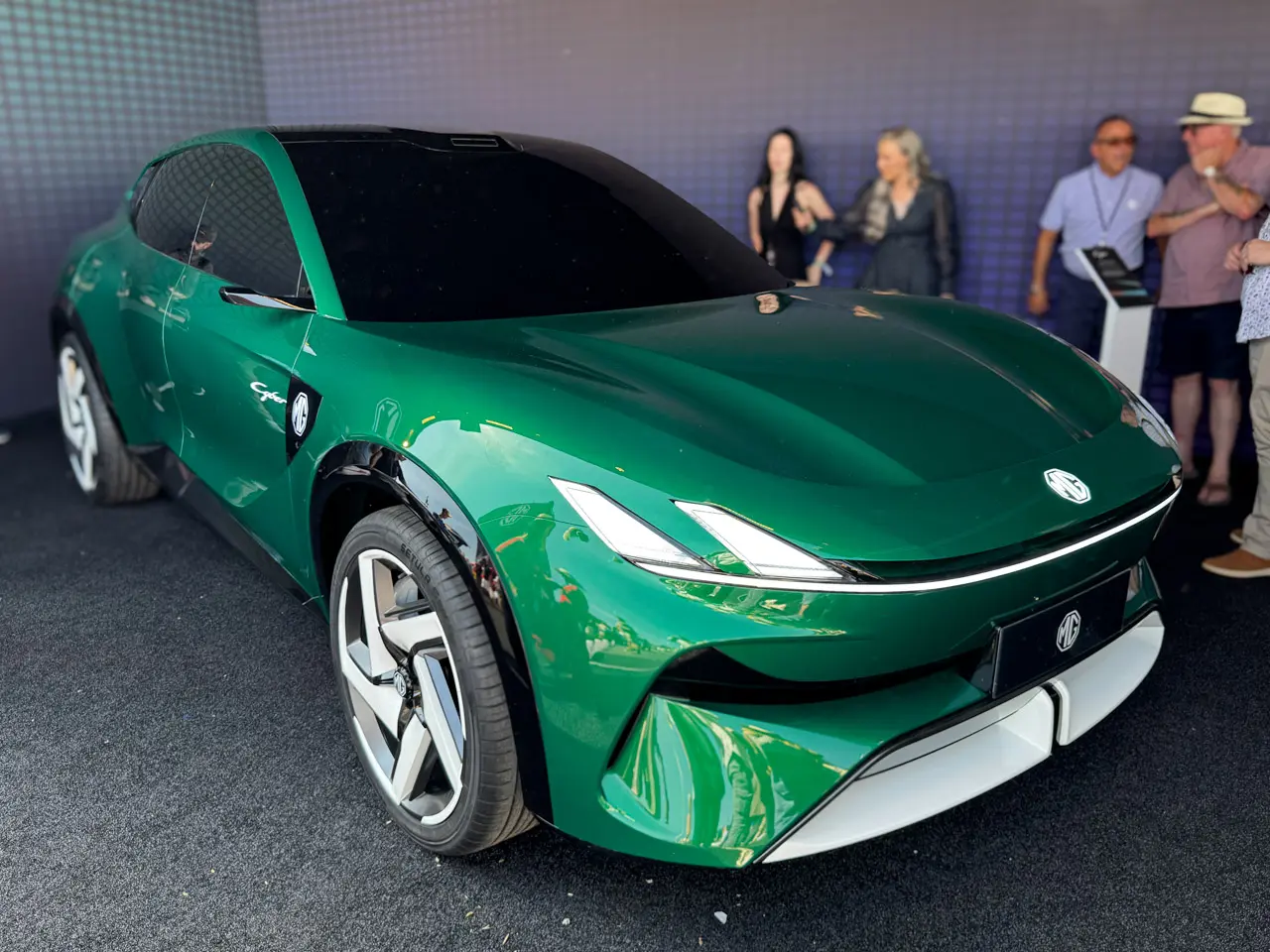 Vista frontal em três-quartos do MG Cyber conceito verde, com capô comprido, faróis finos em garra e emblema MG iluminado
