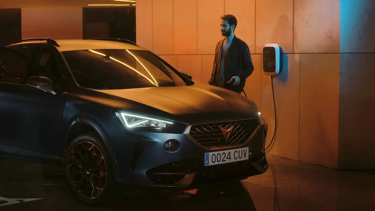 Carro elétrico a carregar numa wallbox doméstica numa garagem à noite